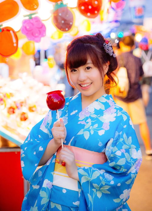 お祭りの屋台でりんご飴を買ってもらった浴衣女子