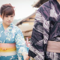 古い町並みで彼の袖を掴む浴衣姿の彼女と彼氏のデート風景の写真