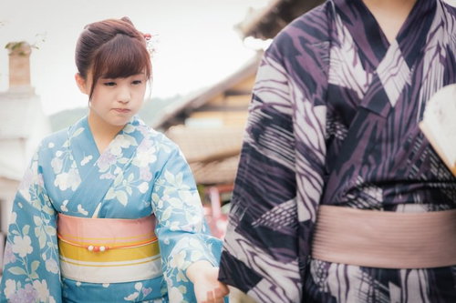 古い町並みで彼の袖を掴む浴衣姿の彼女と彼氏のデート風景