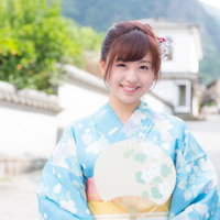 伊万里市大川内山の古い町並みで青い浴衣姿の若い女性がうちわを持って笑顔の写真