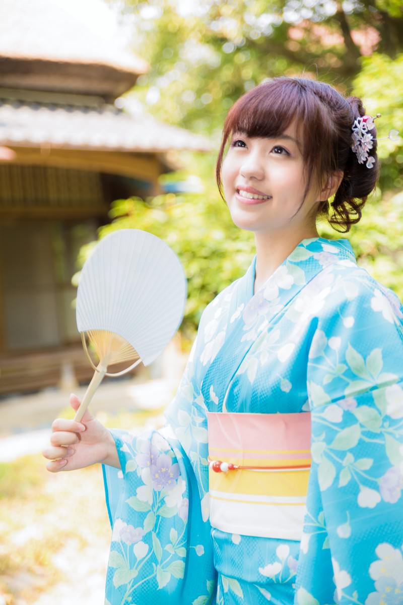 石灯籠のある庭でうちわを持つ浴衣女性［モデル：河村友歌］