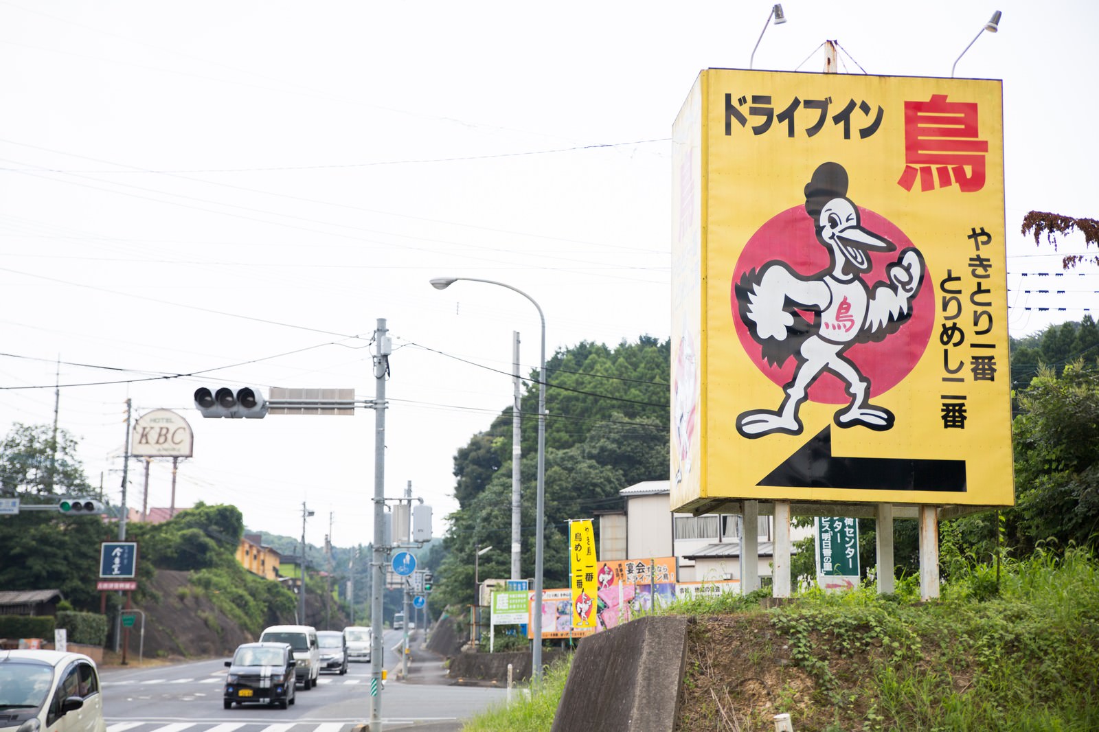 黄色い看板に烏のキャラクターと赤いテキストが入った、県道沿いのドライブイン鳥の大型看板