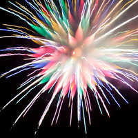 カラフルな炎色反応を起こす夜空の花火大会の光跡の写真