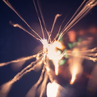 暗闇で燃える小さい火花と炎の軌跡、長時間露光で捉えた光跡の写真