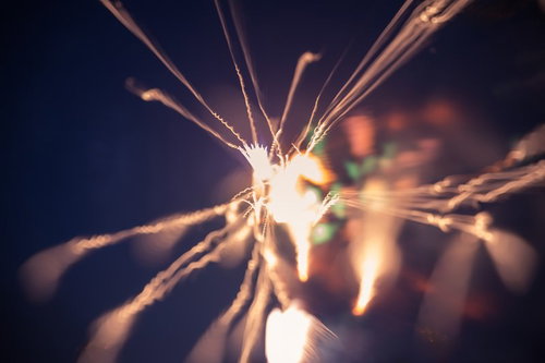 暗闇で燃える小さい火花と炎の軌跡、長時間露光で捉えた光跡