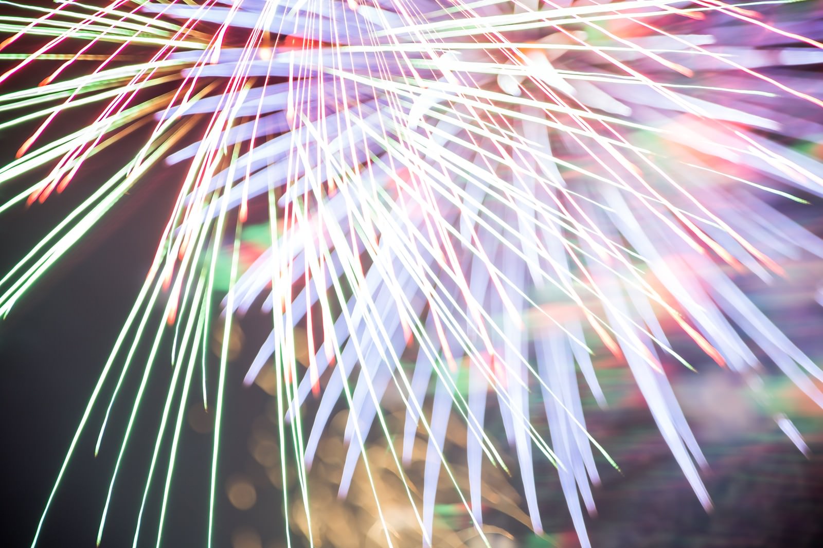 夜空にピンクの花火が放射状に広がる