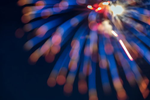 孔雀の羽のように広がる花火と夜空の光の打ち上げ風景