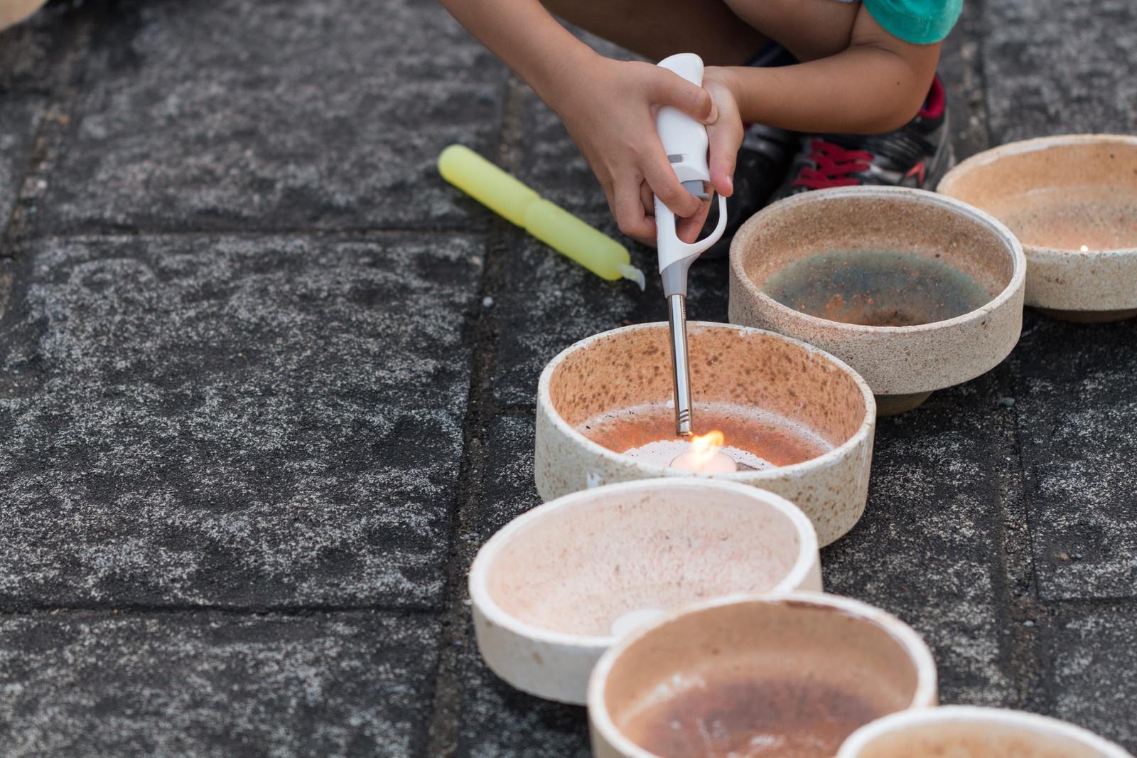 灯ろうに点火する子どもの手元