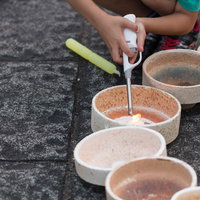 灯ろうに点火する子どもの手元（ボシ灯ろうまつり）の写真