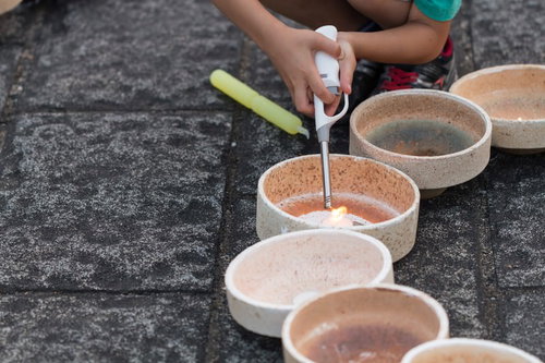 灯ろうに点火する子どもの手元（ボシ灯ろうまつり）