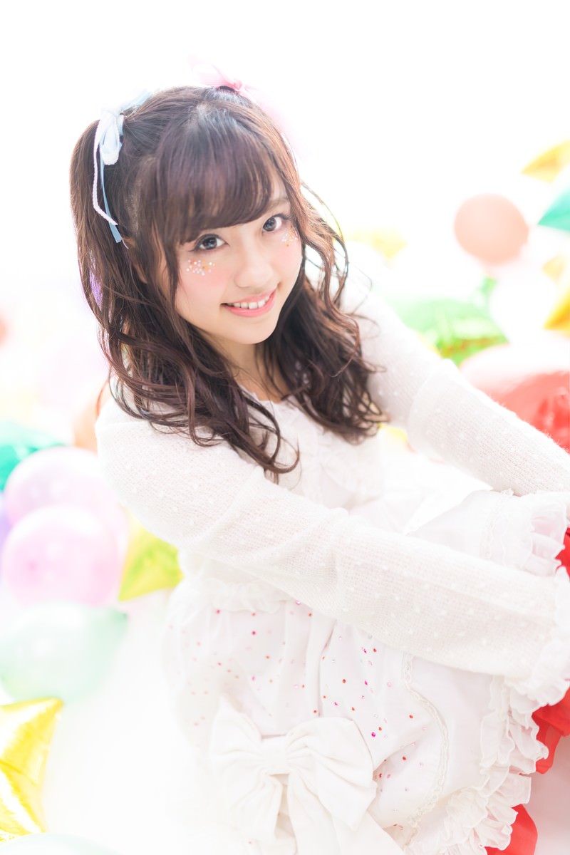 ツインテールでリボンを付けたアイドルの女性がカラフルな風船と一緒に写っている［モデル：河村友歌］