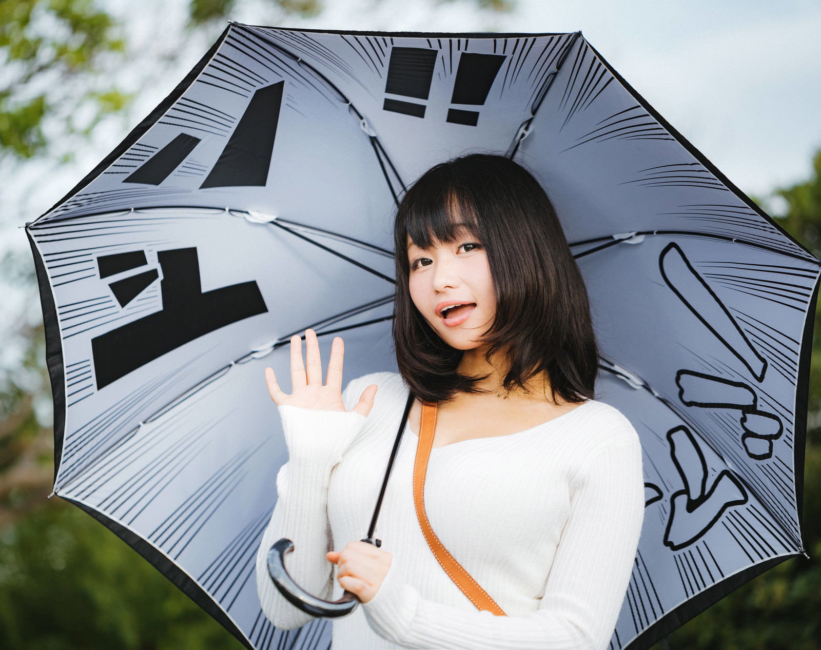 漫画柄の傘を差してポーズする女性［モデル：茜さや］