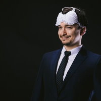 アイマスクを装着しながら目覚めるビジネスマンの写真