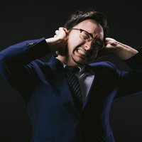 頭痛が痛くて悶え苦しむ外資系社員男性のストレスの写真