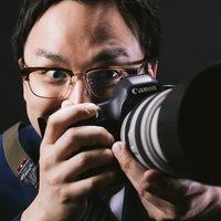 望遠レンズで狙うゲス顔カメラマン男性の怪しい表情の写真