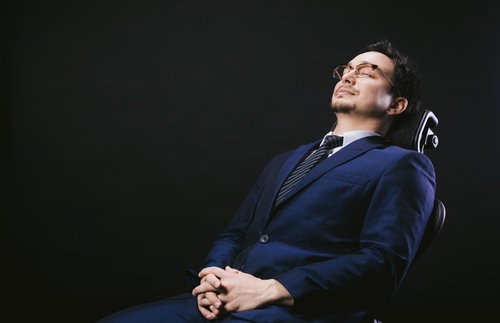 座り心地のいい椅子で寝落ちしている外資系男性