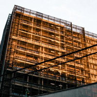 夕日に染まる高層ビルの足場の写真