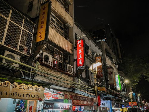 ネオンが灯る台湾の屋台街の路地裏、漢字看板と夜市の賑わい