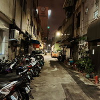 隙間なく詰まった建物と整然と並んだバイクの夜の路地裏の写真