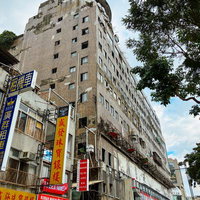 台湾の雑居ビルに掲げられた赤と黄色の看板の写真