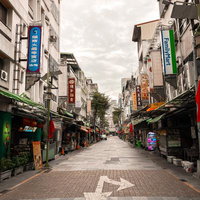 台湾の早朝の下町商店街をまっすぐに伸びる路地の写真