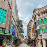ヤシの木が並ぶ台湾の商店街入口の街並みと看板の写真