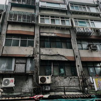 老朽化したビルの外観に並ぶエアコン室外機、台湾の雑居ビルの写真