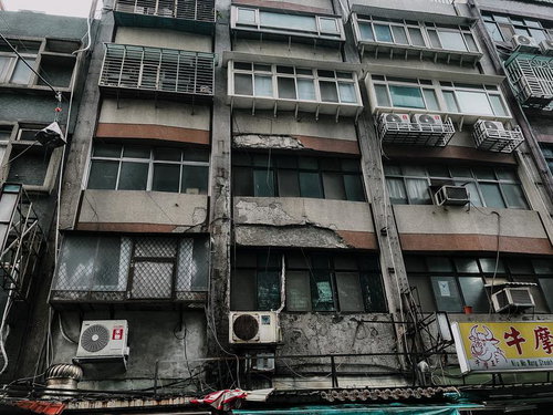 老朽化したビルの外観に並ぶエアコン室外機、台湾の雑居ビル