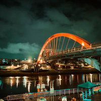 赤いアーチが夜間にライトアップされた台湾の橋の写真