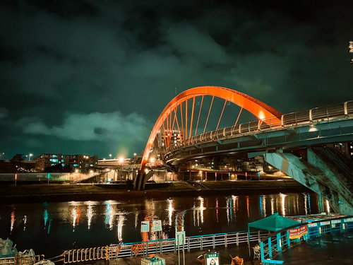 赤いアーチが夜間にライトアップされた台湾の橋