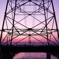 夕焼けグラデーションと送電線鉄塔のシルエットの写真