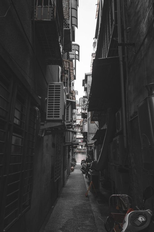 狭く入り組んだ台湾の裏路地、機械室が設置された暗い通路