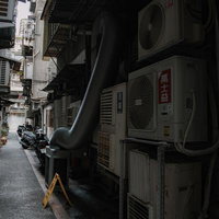 台湾の狭い路地にびっしりと並ぶエアコン室外機と配管の写真