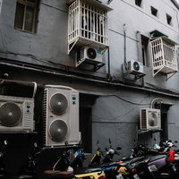 バイクと複数のエアコン室外機が並ぶ台湾の路地裏の写真