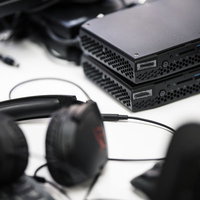 白いデスク上に置かれた黒いNUCとサングラスの写真