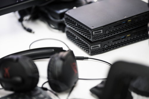 白いデスク上に置かれた黒いNUCとサングラス