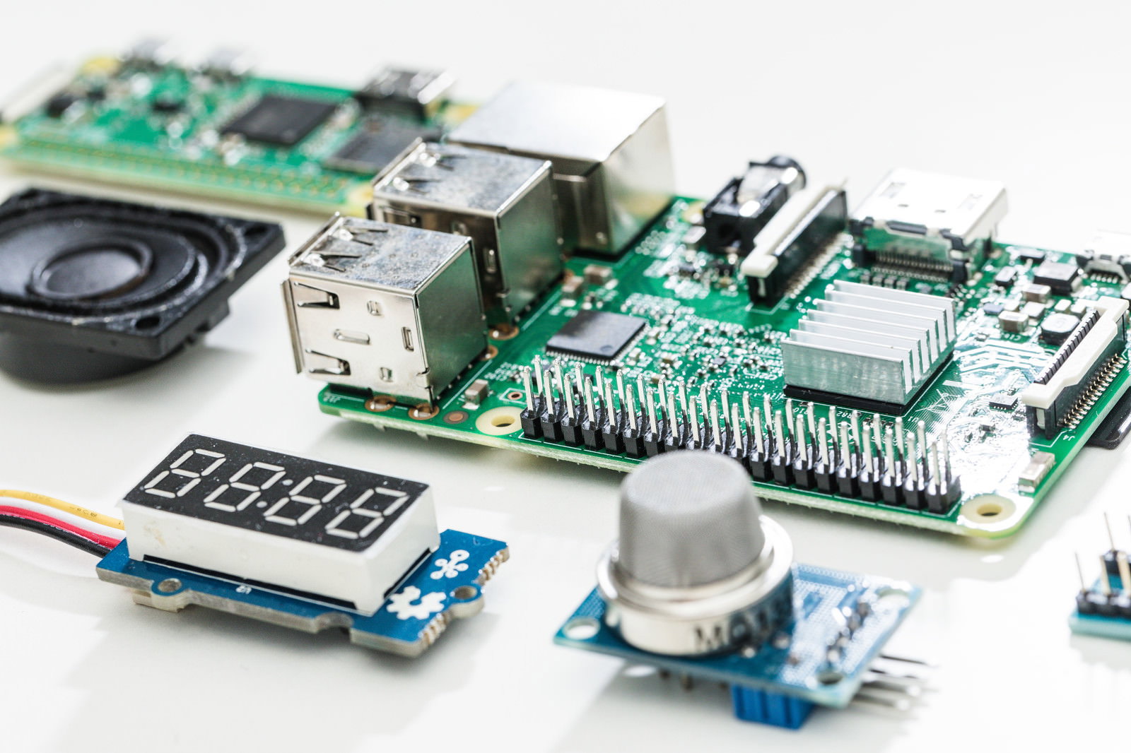 白い背景に配置されたRaspberry Piと空気質センサーなどの電子部品