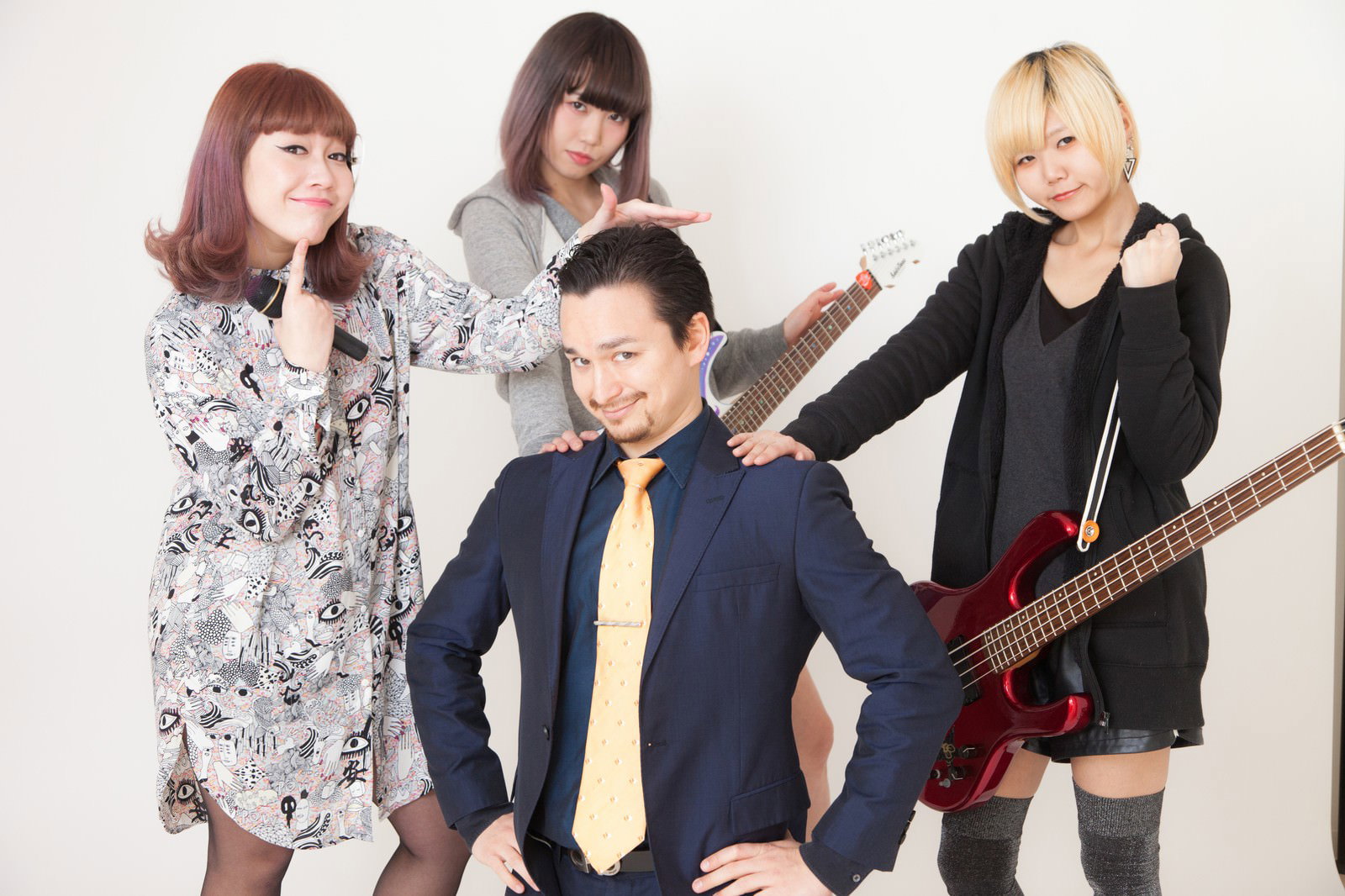 ガールズバンドのメンバーと男性マネージャーが楽器を持って並んでいる［モデル：IRISMONDE Max_Ezaki］