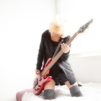 隣の部屋から聞こえるベース音がすごい理由。赤いベースを弾く女性の写真