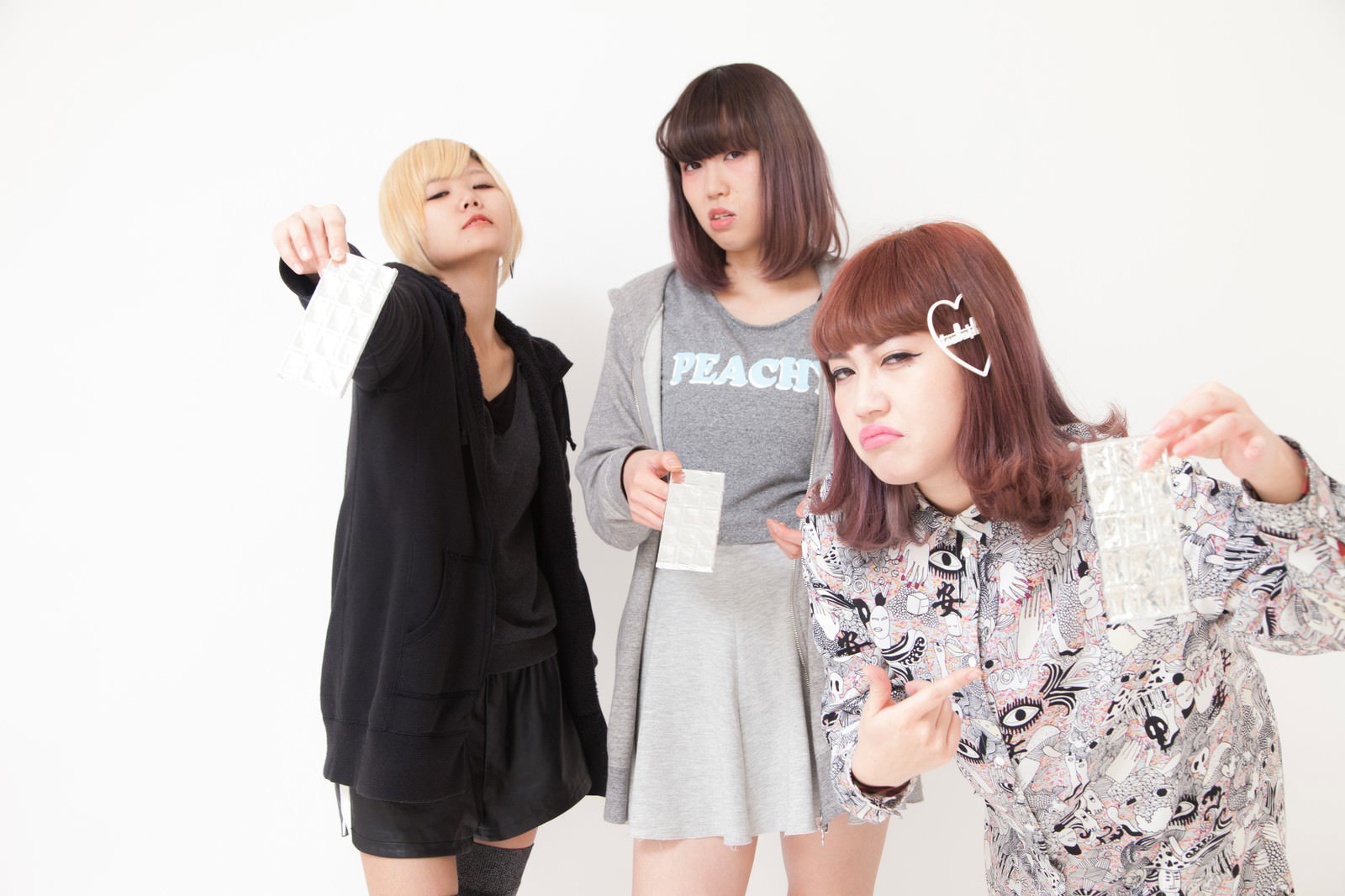 板チョコを持って不満そうな表情をするガールズバンドの4人のメンバー［モデル：IRISMONDE］