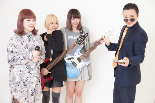 不敵な笑みを浮かべる敏腕スカウトと女ボーカル、ギタリストのバンドメンバーの写真