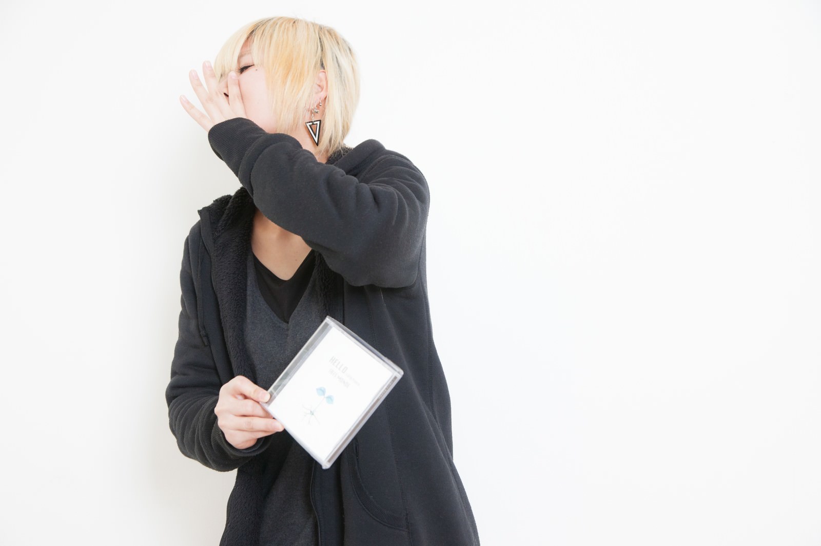 自主制作アルバムを手売りする女性アーティストが力強い表現をしている［モデル：IRISMONDE］