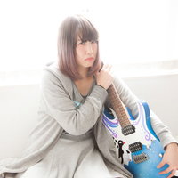 ツアー代が足りなくてギターを守る女性ミュージシャンの写真