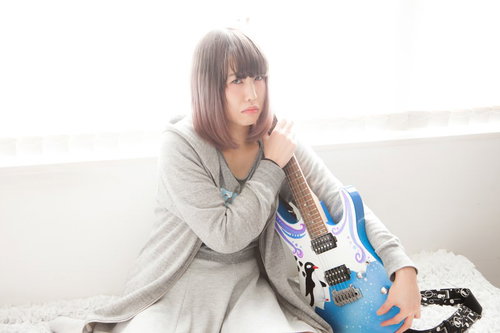 ツアー代が足りなくてギターを守る女性ミュージシャンの写真