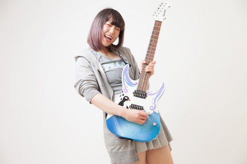 チョーキング時の高揚感で笑顔を見せるギタリスト女性
