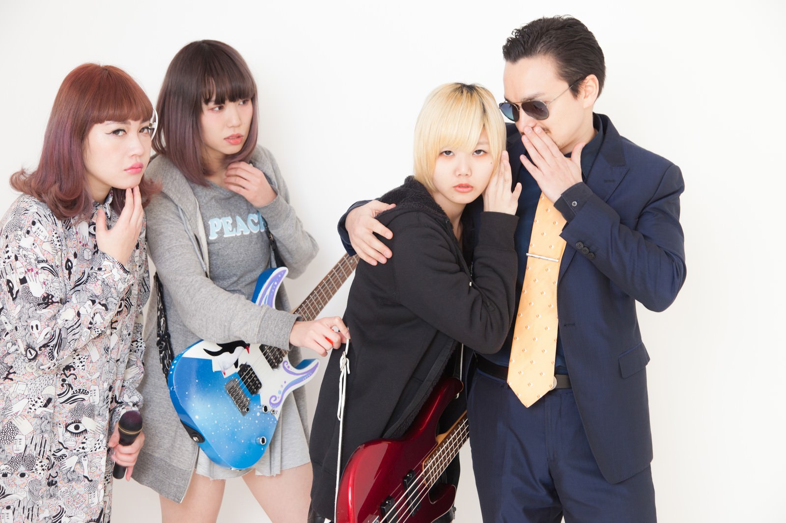 悪質なマネージャーが女性バンドメンバーのベーシストを引き抜こうと耳打ちしている場面［モデル：IRISMONDE Max_Ezaki］