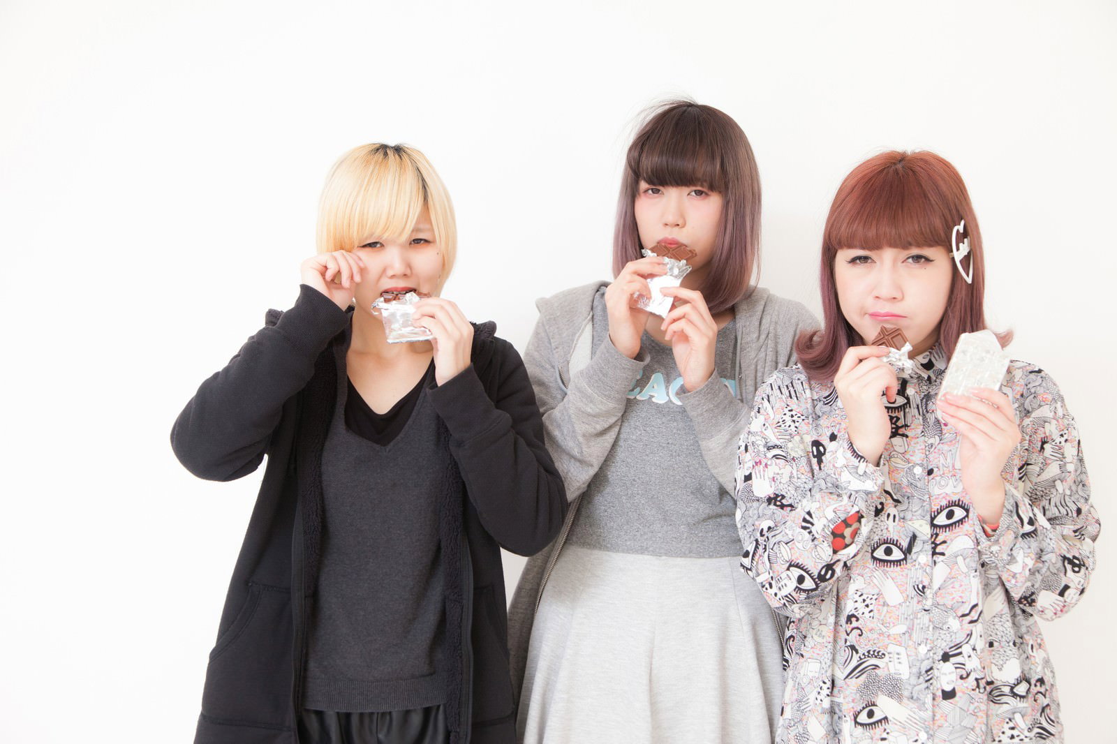 板チョコを食べる3人の女性、金髪・黒髪・赤茶髪、涙ぐむ表情［モデル：IRISMONDE］