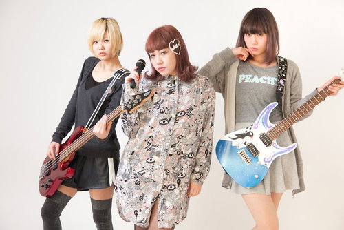 ギターとベースを持つ三人組のガールズバンドの写真