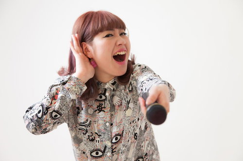 客を煽るマイクを握る女性ボーカルのステージパフォーマンス