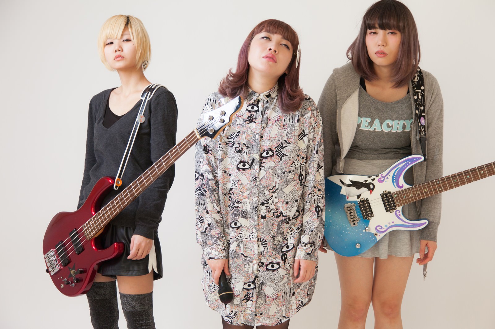 3徹後の脱力した表情のガールズバンドメンバー3人が、ギターを持って並んでいる［モデル：IRISMONDE］